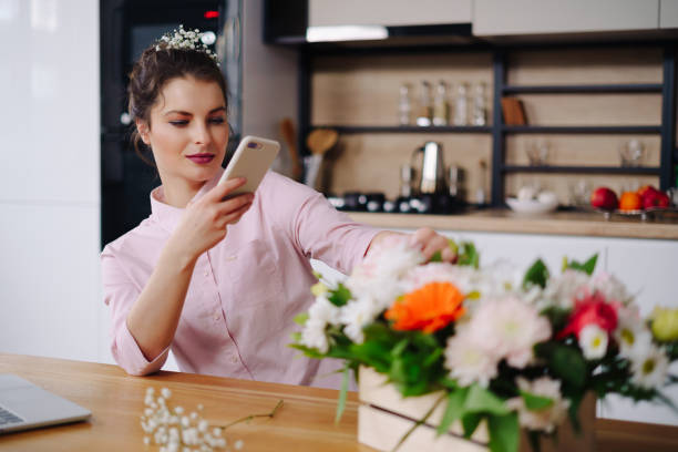 istock Young florist looking at laptop and answering phone call 1294636818