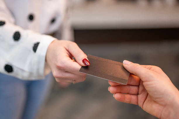 Hands passing a blank business card Female's hands passing a blank business card. passing giving stock pictures, royalty-free photos & images