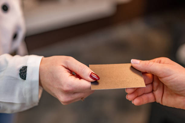 istock Hands passing a blank business card 1294641233