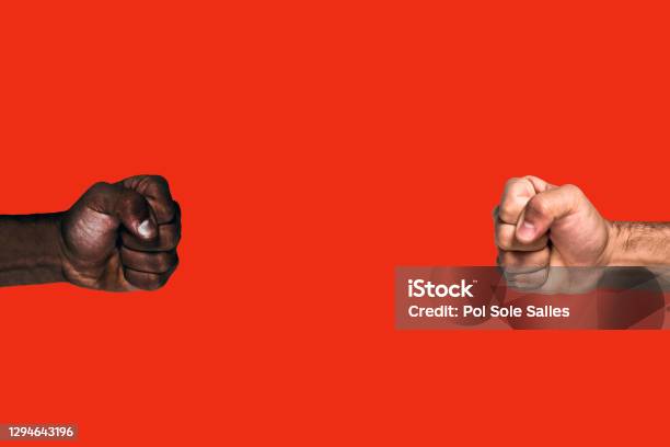 Multicultural Fists Raised African Black Fist And Caucasian White Fist Raised Calling For Freedom And Equality On A Red Background Stock Photo - Download Image Now