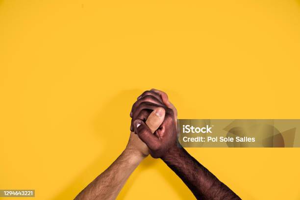 Multicultural Hands United Calling For Freedom And Equality On A Yellow Background African And Caucasian Hands Together Calling For Stop Racism Stock Photo - Download Image Now