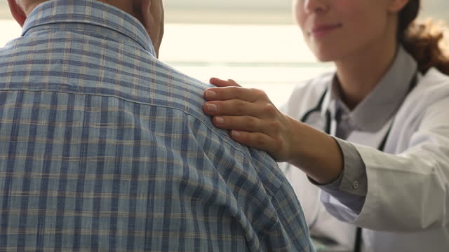 Therapist during pep talk put hand on older patient shoulder