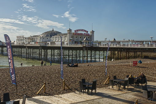 Brighton, England - October 10, 2020: Beach and pier at Brighton, East Sussex, England. With cafe terrace.