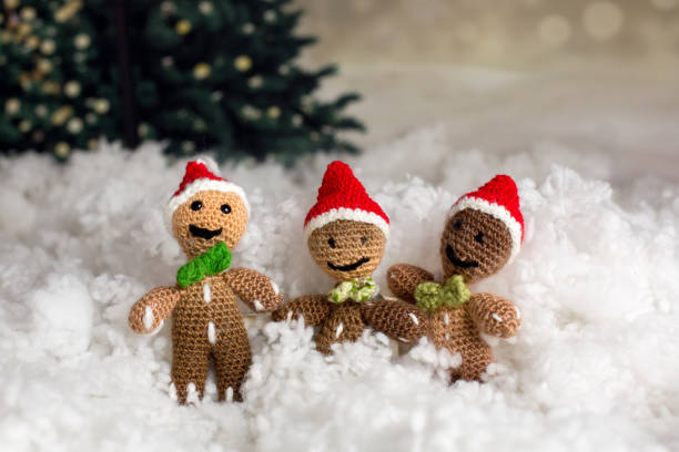 istock Three handmade knitted gingerman toys in a artificial snow 1294651564