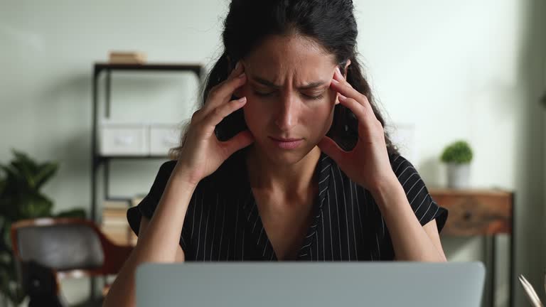 Distressed businesswoman looks at laptop feels frustrated by business failure