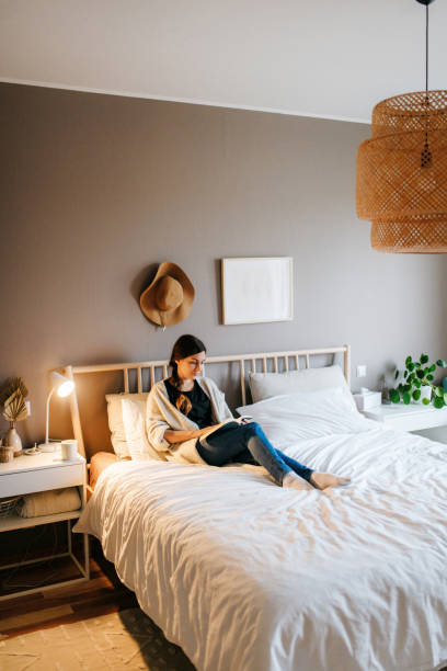istock Young woman reading a book on a bed 1294656459