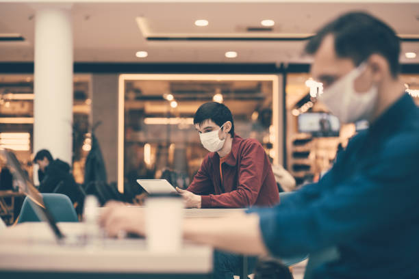 istock cafe patrons in protective masks working on their laptops 1294656818