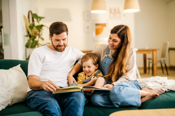 istock Mom and dad reading a book to their son 1294660818