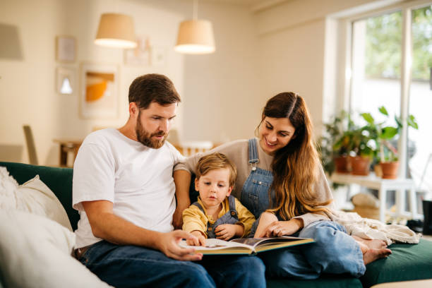 istock Mom and dad reading a book to their son 1294661686