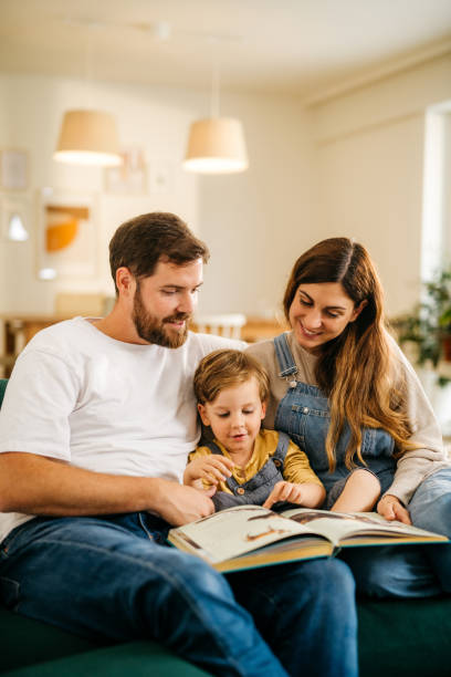 istock Mom and dad reading a book to their son 1294661689