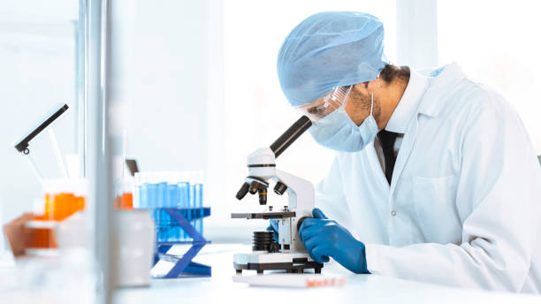 istock close up. scientist looking into the eyepiece of a microscope 1294662978