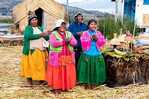 Lake Titicaca, Peru - January 12, 2020: Indigenous People on self-fashioned floating island in Lake Titicaca near Puno.