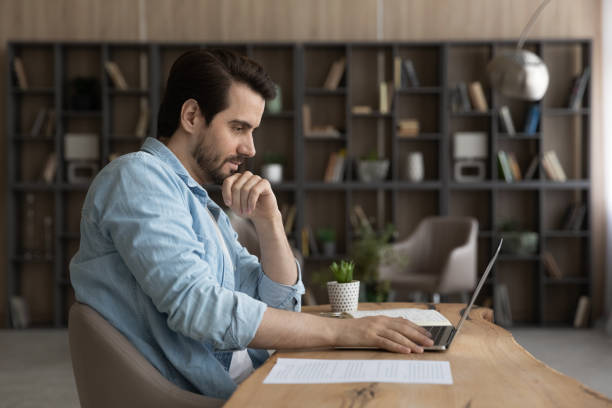 istock Serious male employee work on laptop from home office 1294670660