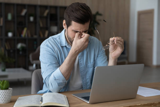 istock Exhausted man suffer from dizziness working on laptop 1294670667