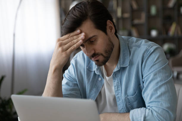 istock Pensive man look at laptop screen thinking 1294670688