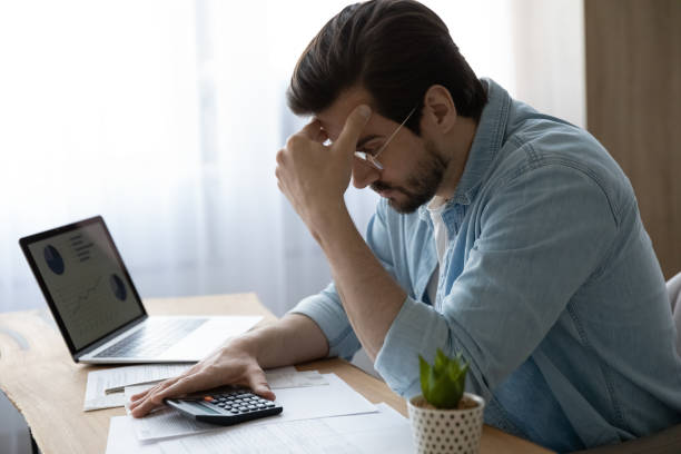 istock Pensive young man calculate household expenses thinking 1294670689