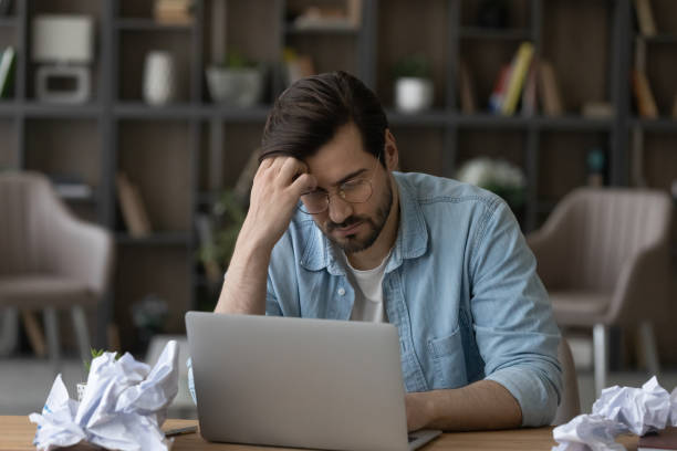istock Tired young man overwhelmed with work at workplace 1294670728