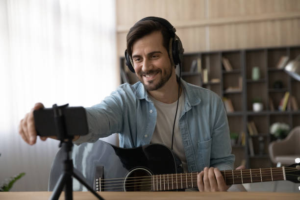 istock Smiling male artist compose music using smartphone 1294670745
