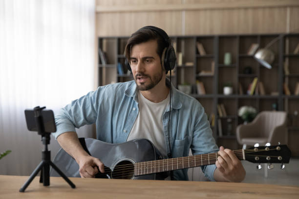istock Millennial male singer record video on cellphone 1294670751