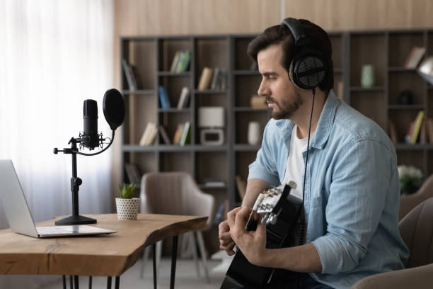 istock Male artist learn playing guitar on video lesson 1294670757