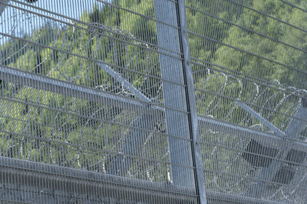 istock barbed wire fence as security measurement in prison 1294672394