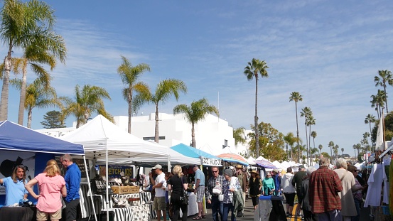 Oceanside, California USA -20 Feb 2020 People walking on marketplace, customers on farmers market. Buyers support business, vendors sell locally produced goods. Outdoor street trading stalls and tents