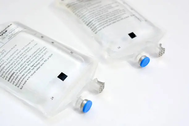 two saline IV bags side by side on white background