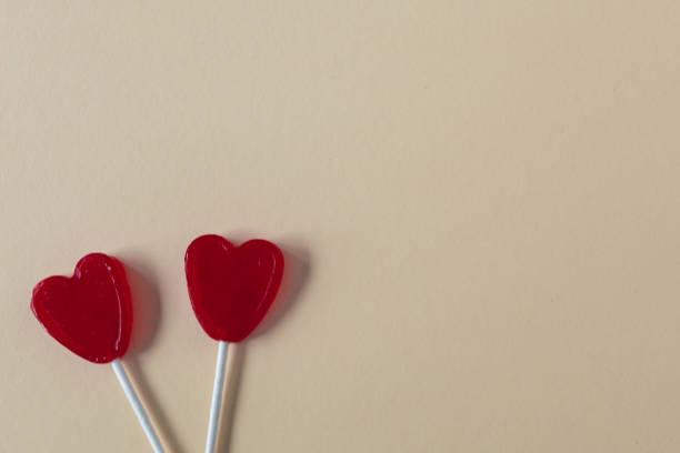 istock selective focus of two red heart shaped lollipops on a cream colored background Valentine's Day concept 1294675939