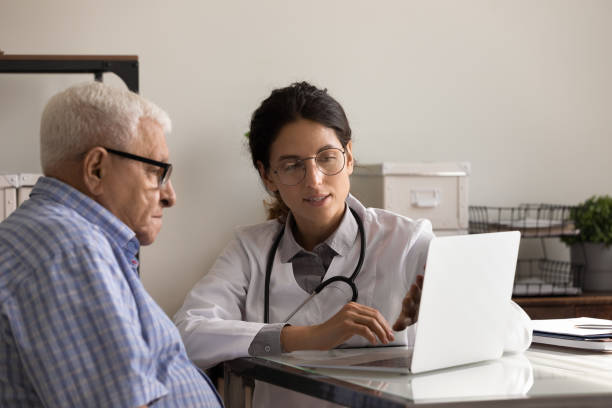 istock Female doctor consult senior male patient using computer 1294678930