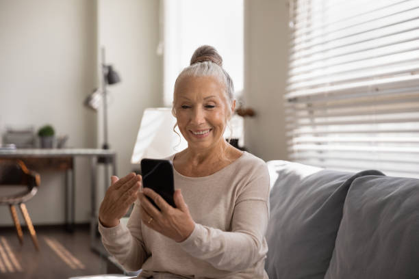 istock Smiling elderly woman talk on video call on cell 1294678933