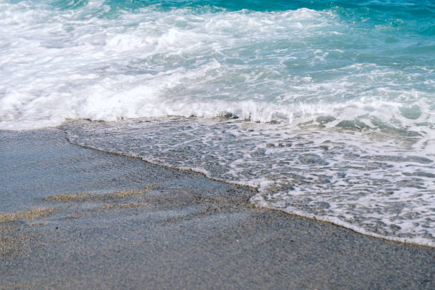 istock White foamy waves on sandy beach closeup. 1294679277