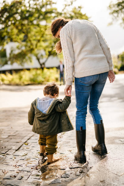 istock Little boy puddle jumping with his mom 1294680047
