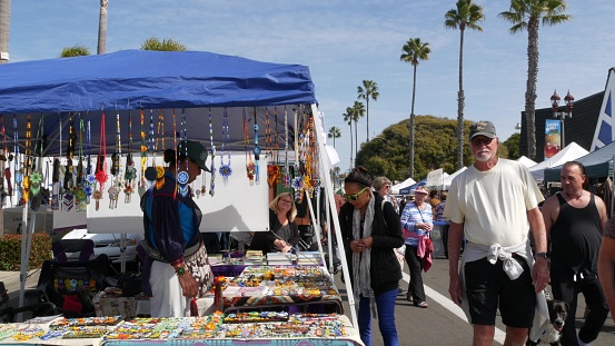 Oceanside, California USA -20 Feb 2020 People walking on marketplace, customers on farmers market. Buyers support business, vendors sell locally produced goods. Outdoor street trading stalls and tents