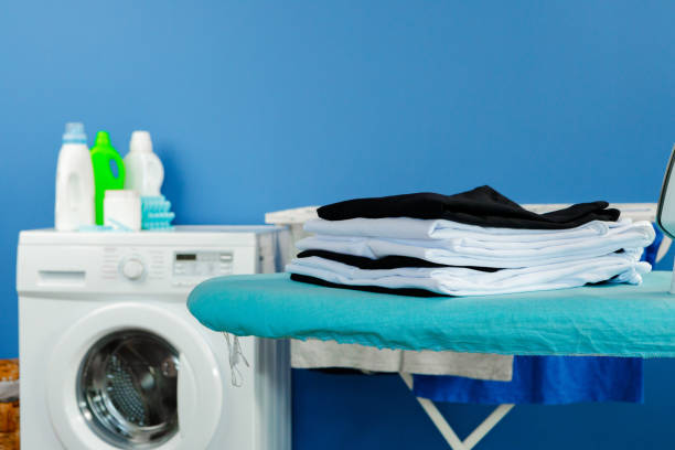istock Housekeeping concept. Washing machine and ironing board 1294693959