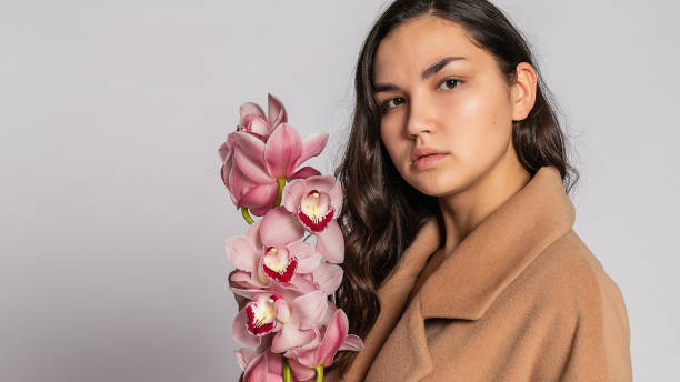 istock Seductive blonde woman in brown jacket posing in studio 1294695431