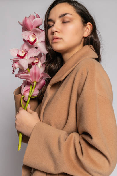 istock Seductive blonde woman in brown jacket posing in studio 1294695443