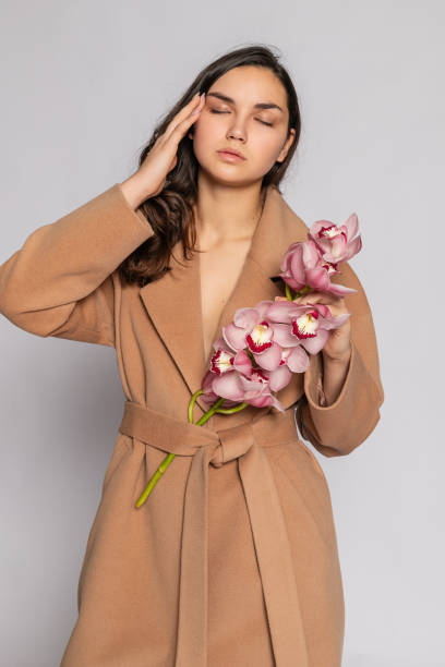 istock Seductive blonde woman in brown jacket posing in studio 1294695511