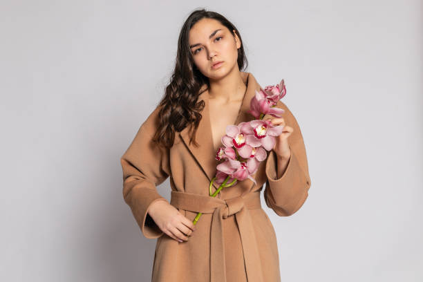 istock Seductive blonde woman in brown jacket posing in studio 1294695522