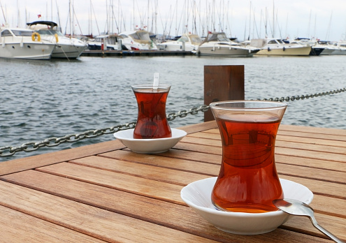 Istanbul, Turkey-August 22, 2015: Turkish Style Brewed Black Tea in a Marina, Tea Enjoyment by the Sea.