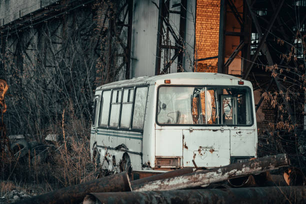 istock Old rusty broken abandoned bus in dark industrial post apocalyptic landscape 1294697269