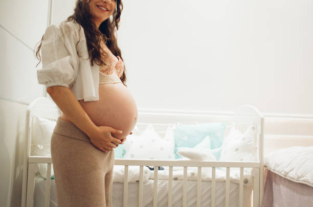 istock Pregnant woman next to the crib 1294697601