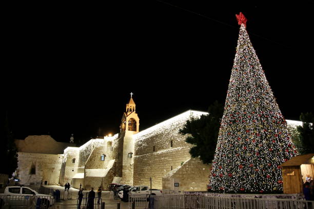 Selected photos from Manger Square in Bethlehem, the Cradle of Christ, showing the Church of the Nativity and the Christmas Tree on Christmas Eve for the Eastern sects, showing the details and walls of the adjacent houses, the balconies and the Omar Bin Mosque, the pendant lighting, and the beautiful decor. Around the place.
