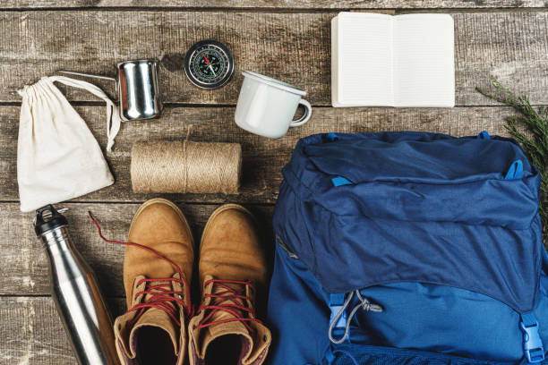 istock Backpack and hiking equipment on wooden background, top view 1294701275