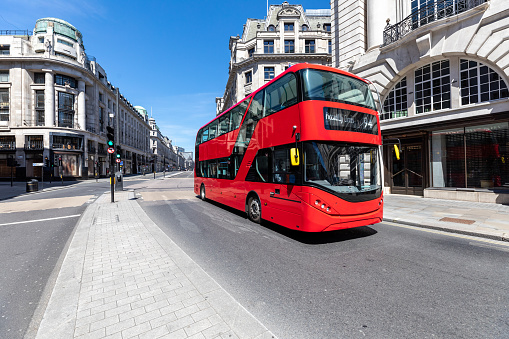 Empty Regent street in London during lockdown, one red double decker bus only on the street
