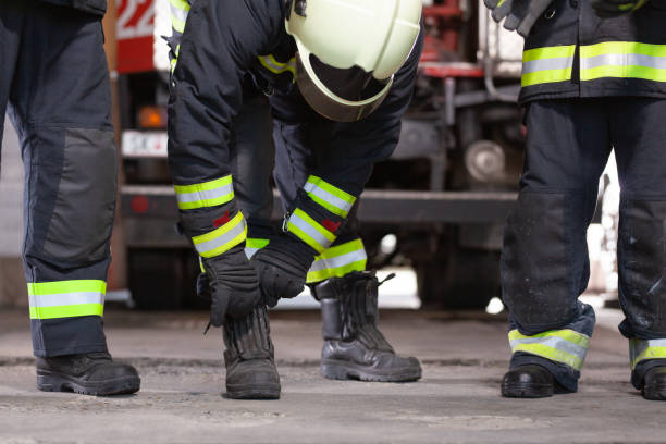 istock Abstract professional firefighters wearing uniforms and protective helmets. Firetruck in the background. 1294705815