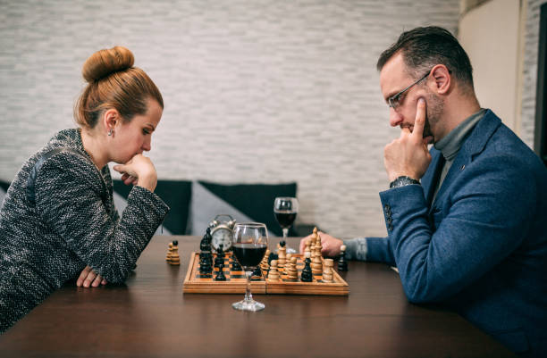 istock Couple playing chess while sitting at table at home 1294706986
