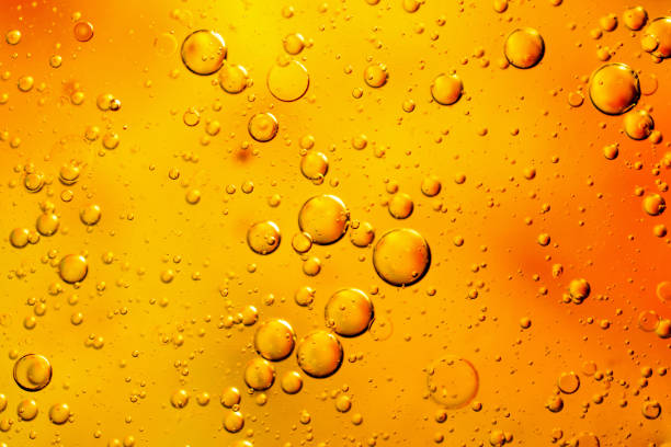 istock oil drops on water on an orange background 1294708957