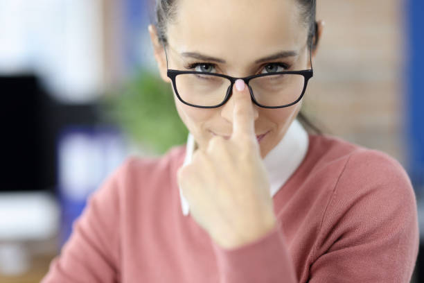 Young woman hand adjusting glasses for vision
