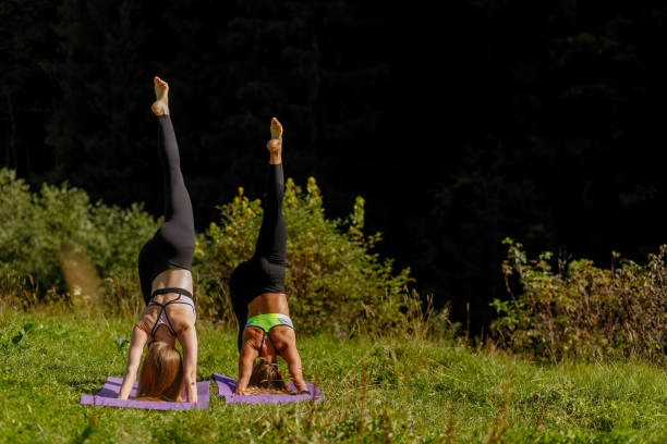 istock Fitness women in triangle pose while practising yoga at a park. 1294716580