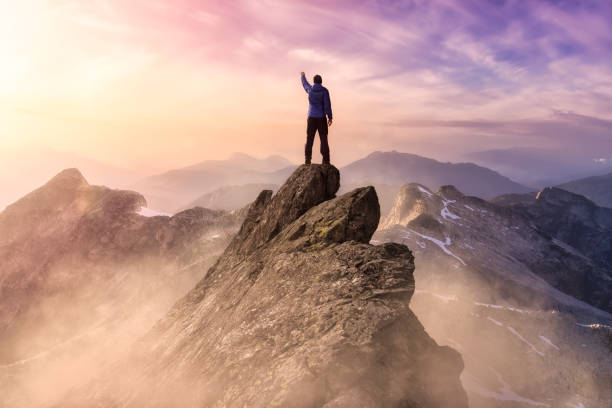 istock Man on top of a Mountain Cliff 1294741671